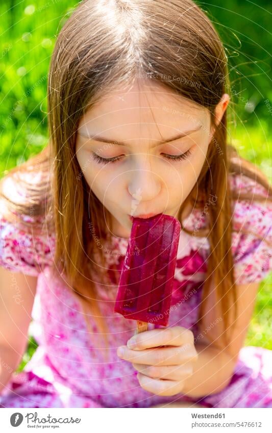 Portrait of girl eating popsicle in garden females girls portrait portraits gardens domestic garden Popsicle Popsicles child children kid kids people persons