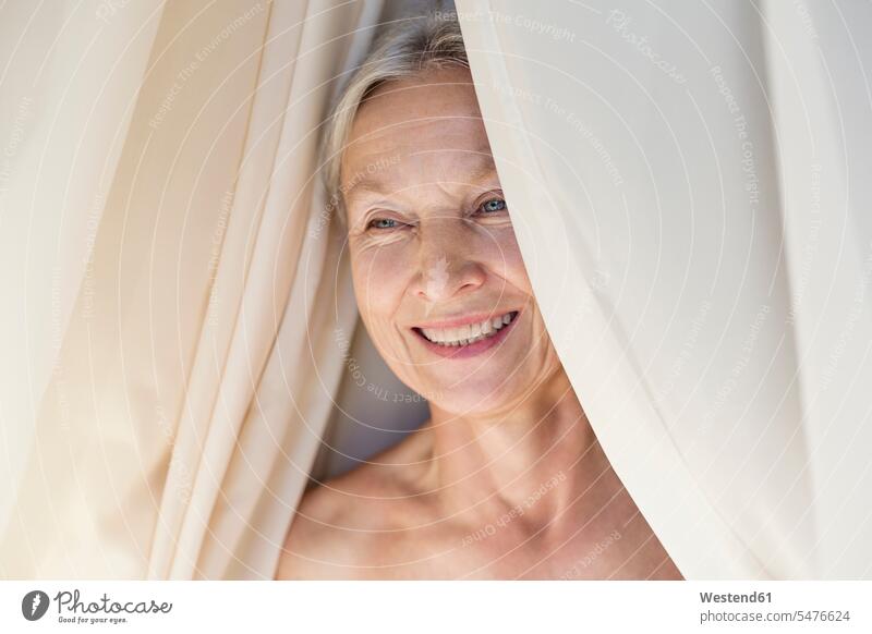 Portrait of relaxed senior woman behind curtain Curtain Curtains Drapery Draperies portrait portraits females women senior women elder women elder woman old