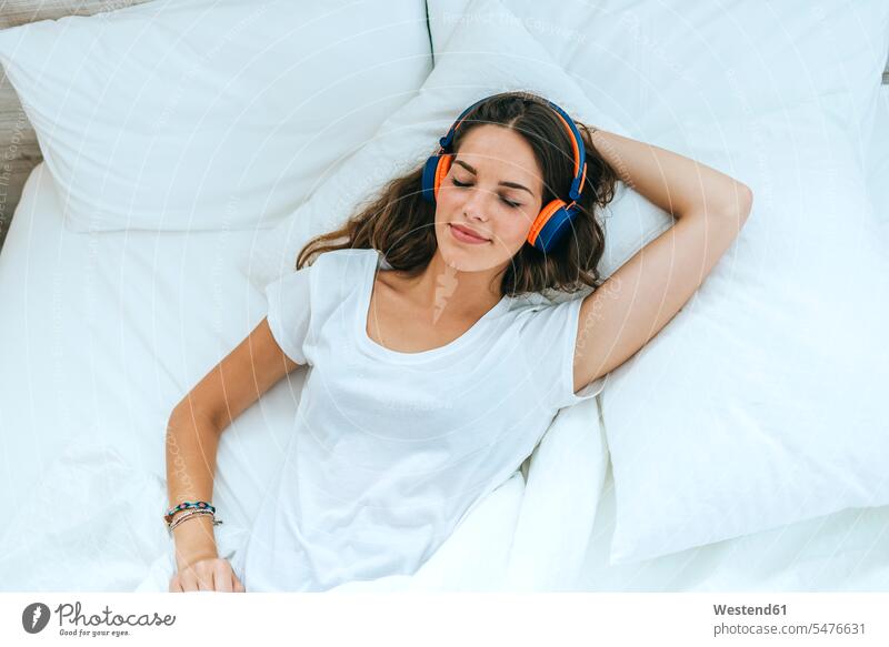 Young woman sleeping in bed at home with headphones human human being human beings humans person persons caucasian appearance caucasian ethnicity european 1