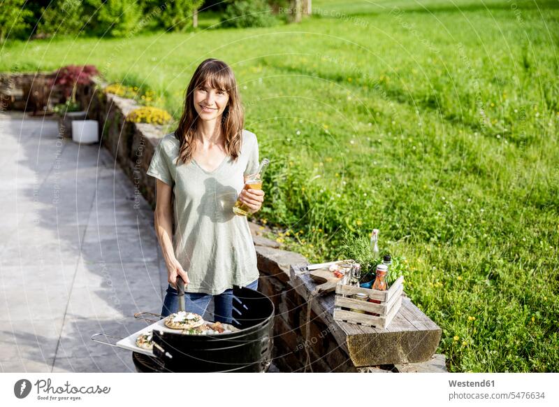 Portrait of smiling woman preparing food on barbecue grill human human being human beings humans person persons caucasian appearance caucasian ethnicity