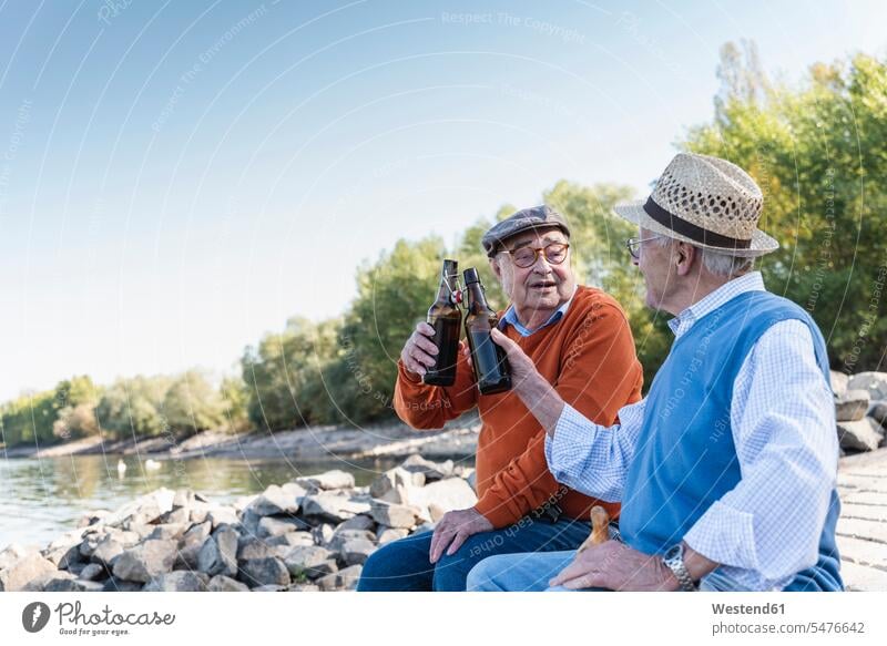 Old friends sitting by the riverside, drinking beer Young at Heart youthful quality of life Taking a Break resting break enjoying indulgence enjoyment savoring