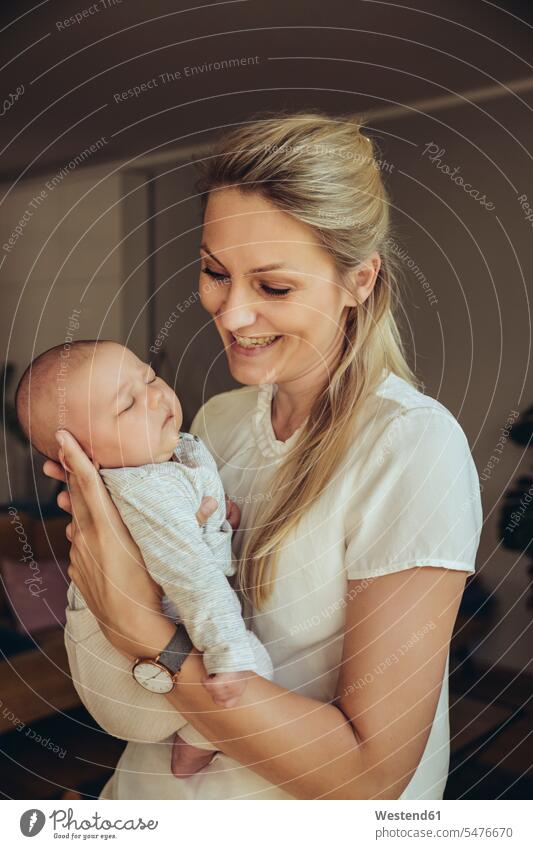 Smiling mother holding sleepy newborn baby smiling smile newborns newborn child infants nurselings babies mommy mothers ma mummy mama people persons human being