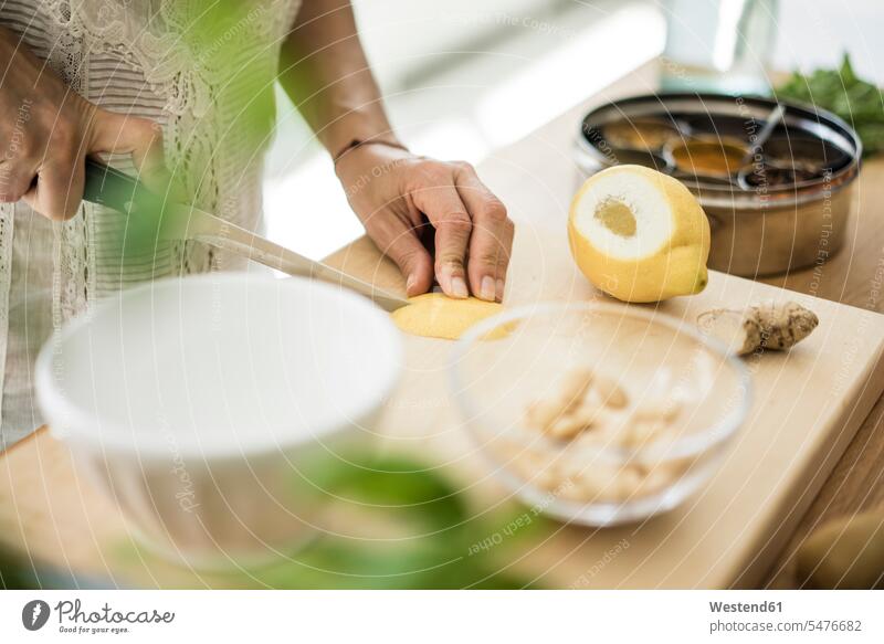 Woman preparing healthy food in her kitchen Fruit Fruits Food Preparation preparing food lemon peel lemon zest chopping foods food and drink Nutrition