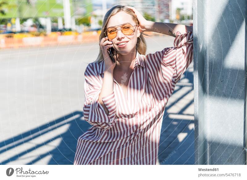 Portrait of blond young woman on the phone outdoors blond hair blonde hair portrait portraits call telephoning On The Telephone calling females women people