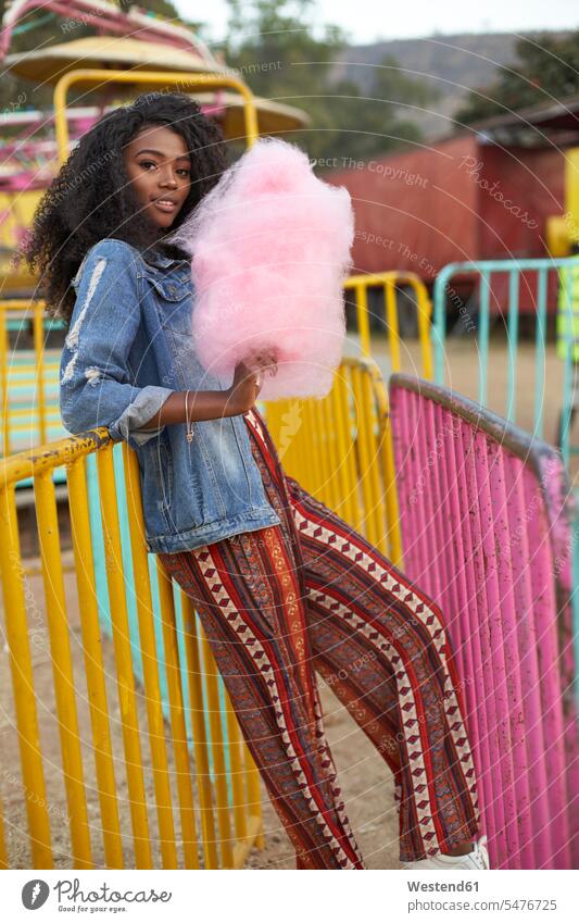 Portrait of smiling young woman with pink candyfloss at fair smile in the evening delight enjoyment Pleasant pleasure Contented Emotion pleased colour colours