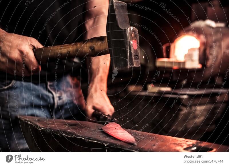 Knife maker at work, steel splinter during hammering damask steel human human being human beings humans person persons caucasian appearance caucasian ethnicity