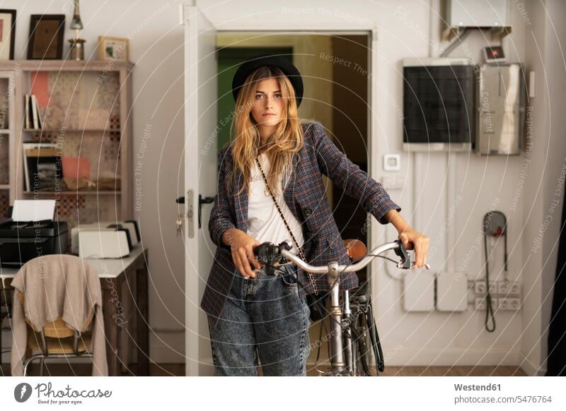 Portrait of a young woman with bicycle in a studio studios females women bikes bicycles portrait portraits Adults grown-ups grownups adult people persons