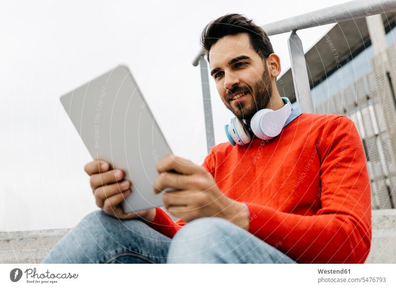 Casual businessman sitting stairs in the city, using his digital tablet and headphones use Businessman Business man Businessmen Business men stairway headset