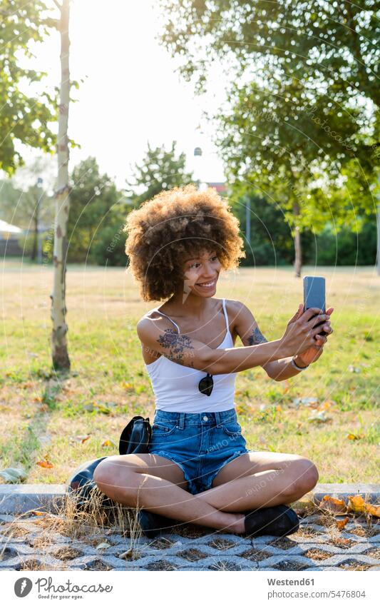 Portrait of tattooed young woman taking selfie with smartphone in summer human human being human beings humans person persons Mixed Race mixed race ethnicity