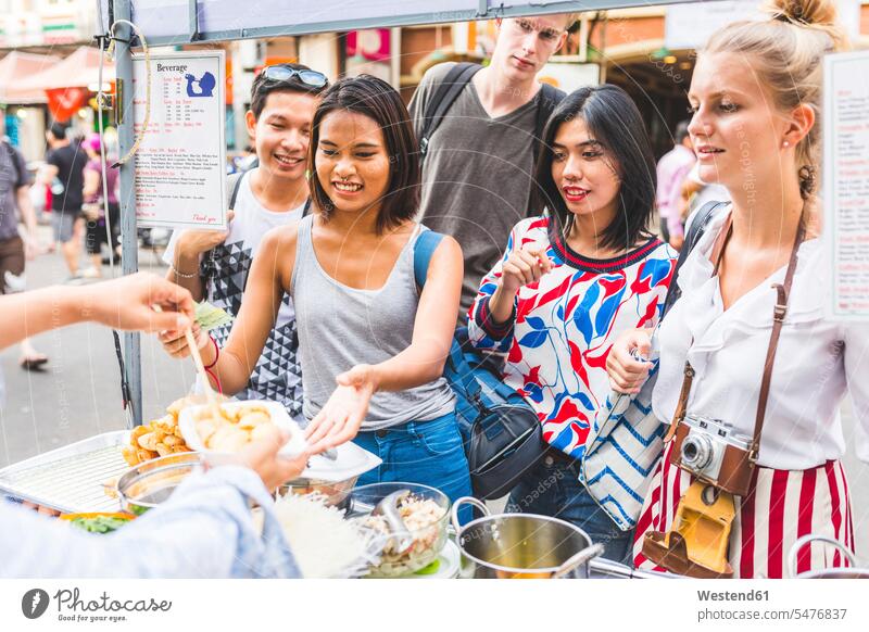 Thailand, Bangkok, Khao San Road, group of friends testing local food on street market sampling group of people Group groups of people city town cities towns