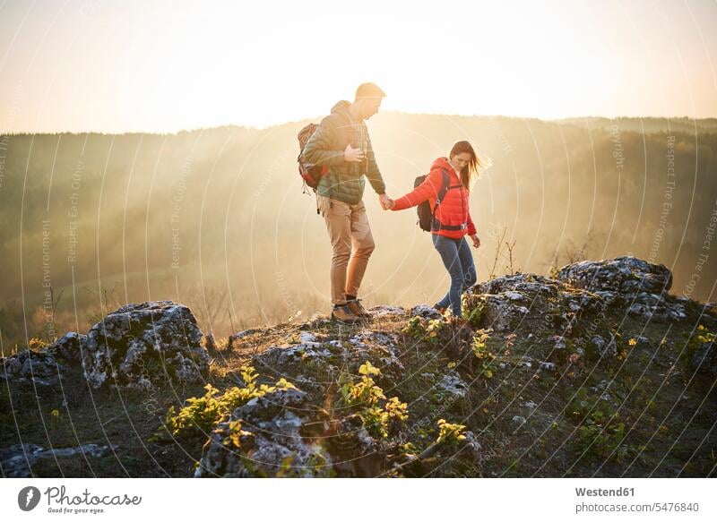Couple on a hiking trip in the mountains walking on rocks excursion Getaway Trip Tours Trips couple twosomes partnership couples going hike hiking tour