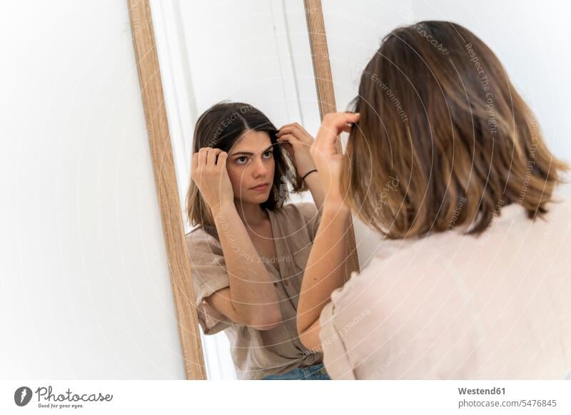 Brunette young woman looking in mirror mirrors at home controlling Everyday Everyday Scene Everyday Scenes Routine Attractiveness beautiful good-looking