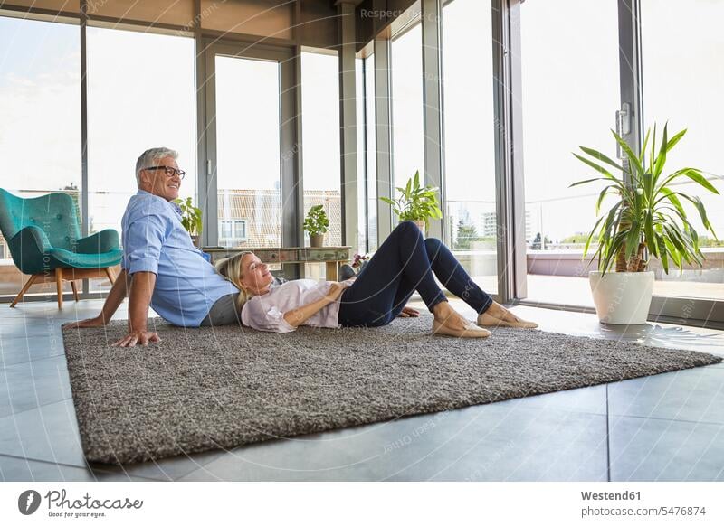 Mature couple relaxing at home on carpet twosomes partnership couples carpets rug rugs relaxed relaxation people persons human being humans human beings