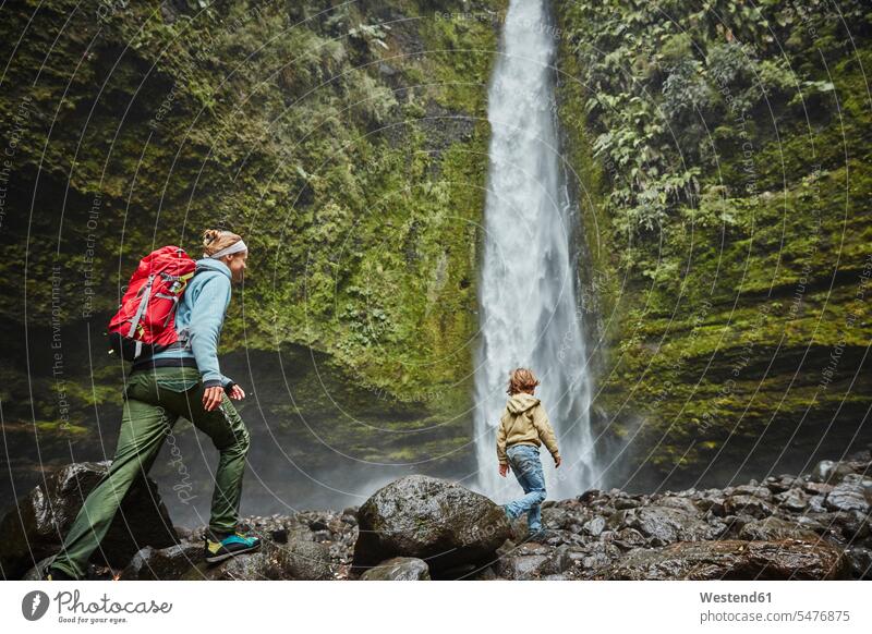 Chile, Patagonia, Osorno Volcano, mother and son walking at Las Cascadas waterfall going boy boys males waterfalls sons manchild manchildren mommy mothers mummy