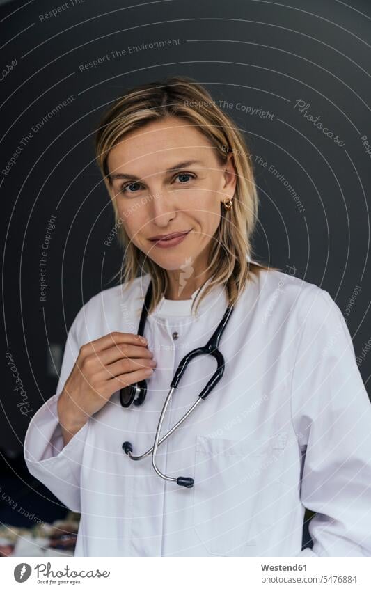 Portrait of doctor with stethoscope against grey background Occupation Work job jobs profession professional occupation work cloth work clothes workwear health