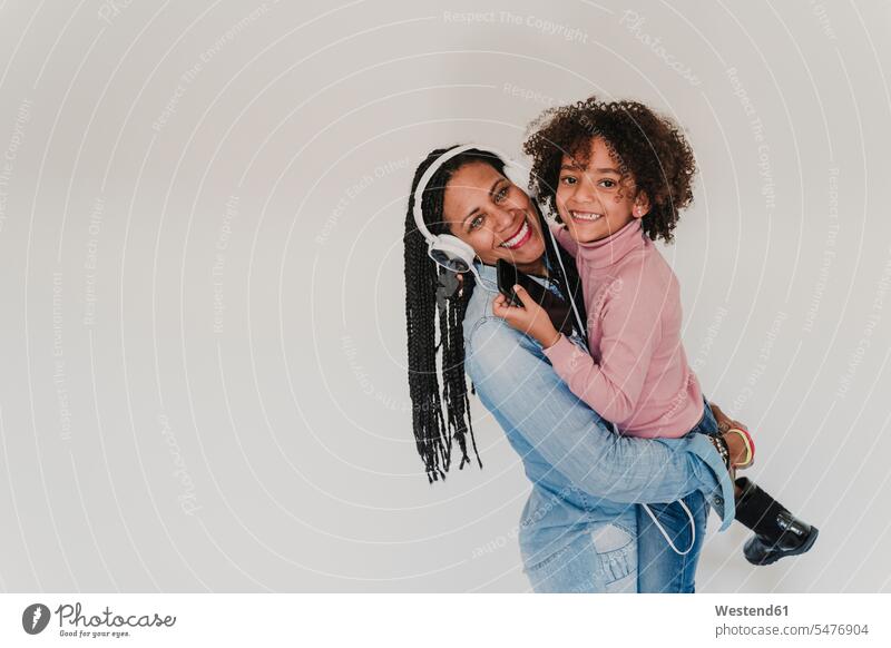 Portrait of happy mother and her little daughter headphone headset cell phone cell phones Cellphone mobile mobile phones mobiles relax relaxing hold hear