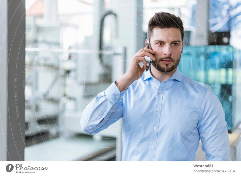 Portrait of man on cell phone in factory factories portrait portraits on the phone call telephoning On The Telephone calling men males mobile phone mobiles