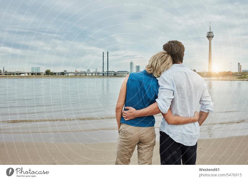 Germany, Duesseldorf, affectionate young couple at Rhine riverbank Affection Affectionate River Rivers twosomes partnership couples riverside water waters