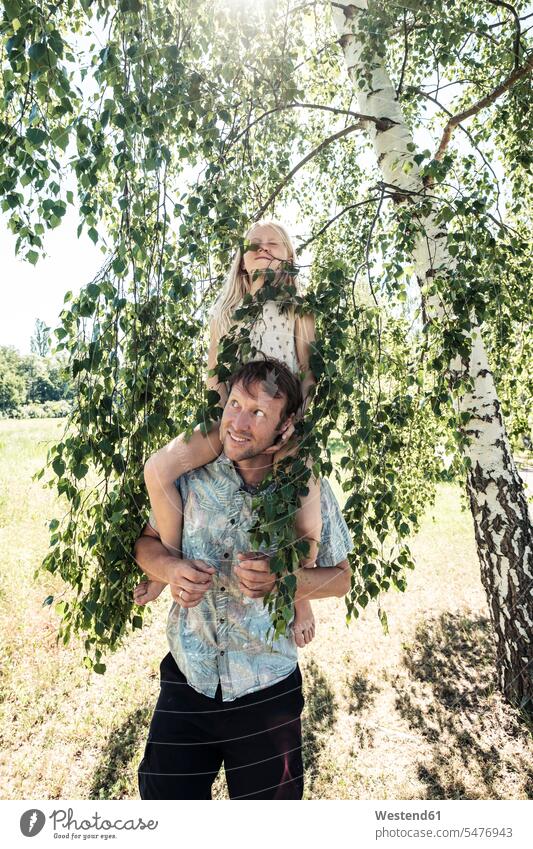 Father carrying daughter piggyback under a birch tree feel go going walk smile play seasons spring season Spring Time springtime summer time summertime summery
