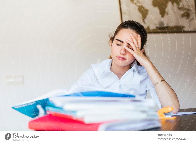 Frustrated female student with documents at desk at home Tables desks learn Seated sit study pessimistic Emotions Feeling Feelings Sentiment Sentiments