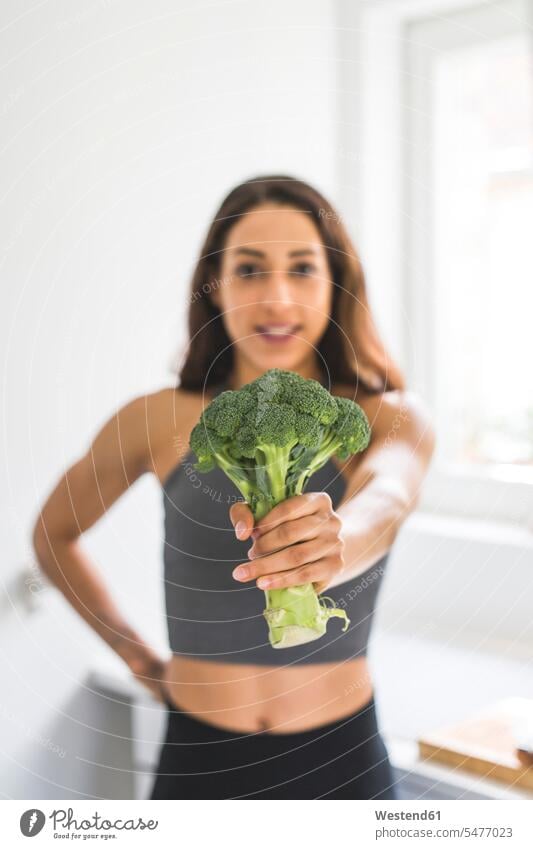 Woman holding a broccoli Broccoli Broccolis woman females women Cabbage Wild Cabbage Cabbages Vegetable Vegetables Food foods food and drink Nutrition
