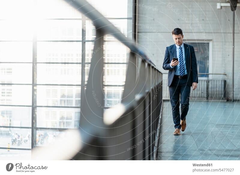 Businessman with cell phone on the move mobile phone mobiles mobile phones Cellphone cell phones Business man Businessmen Business men on the way on the go