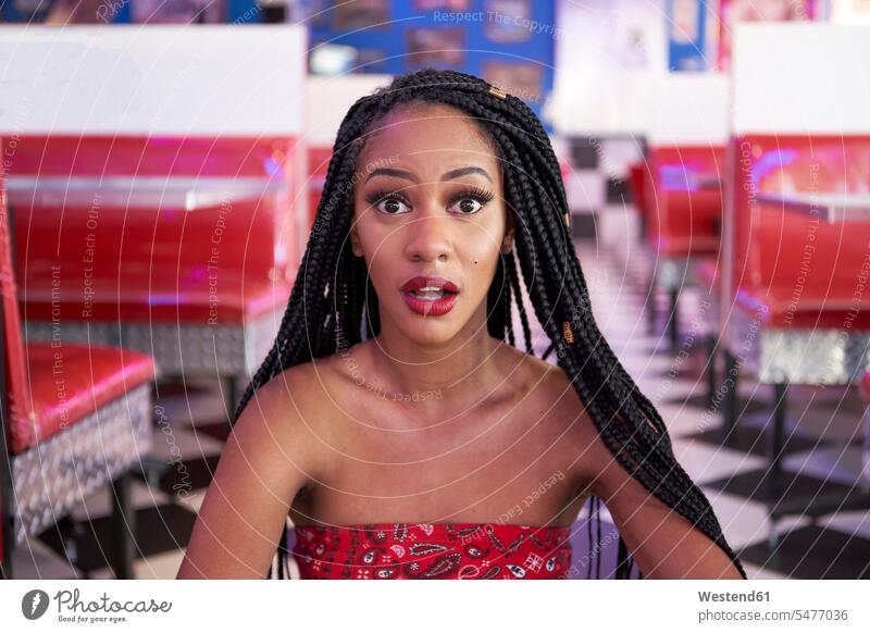 Portrait of a young woman with braided hairstyle in an american diner restaurant Mimic surprising surprised Contented Emotion pleased White Colors free time