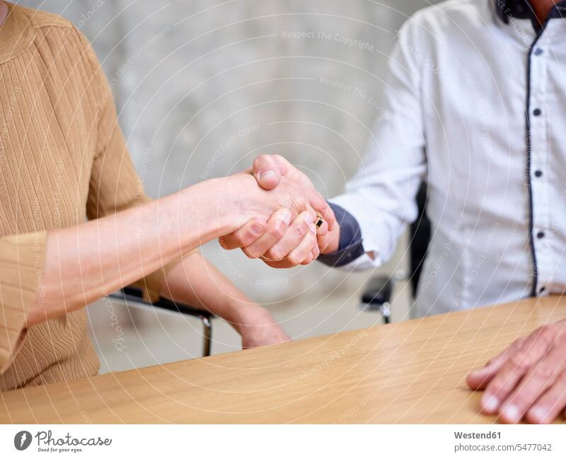 Close-up of businessman and businesswoman shaking hands Handclasp Handclap businesswomen business woman business women Businessman Business man Businessmen