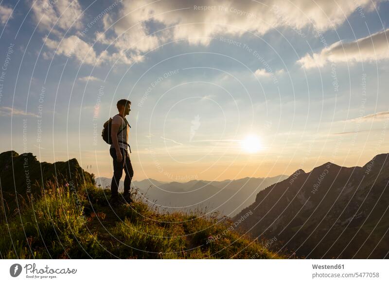 Germany, Bavaria, Oberstdorf, man on a hike in the mountains looking at view at sunset hiking View Vista Look-Out outlook men males sunsets sundown Adults