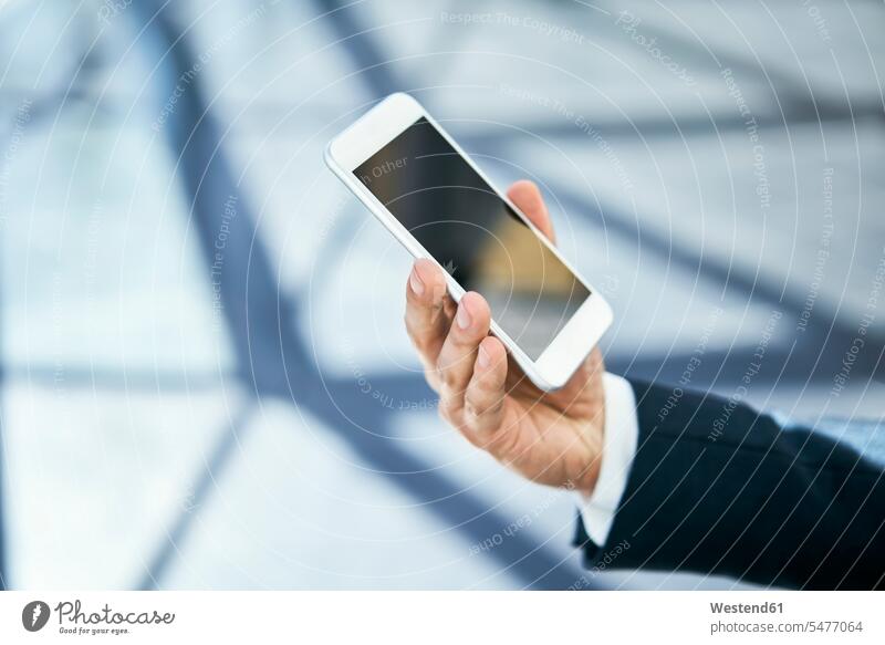 Close-up of businessman holding cell phone Businessman Business man Businessmen Business men mobile phone mobiles mobile phones Cellphone cell phones