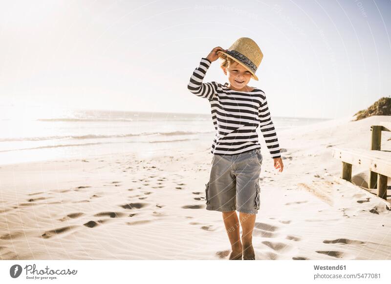 Portrait of smiling boy with hat on the beach hats go going walk smile play seasons summer time summertime summery delight enjoyment Pleasant pleasure
