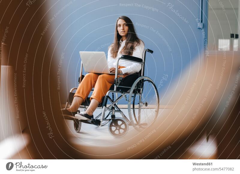 Young handicapped woman sitting in wheelchair, using laptop females women confidence confident serious earnest Seriousness austere working At Work Seated