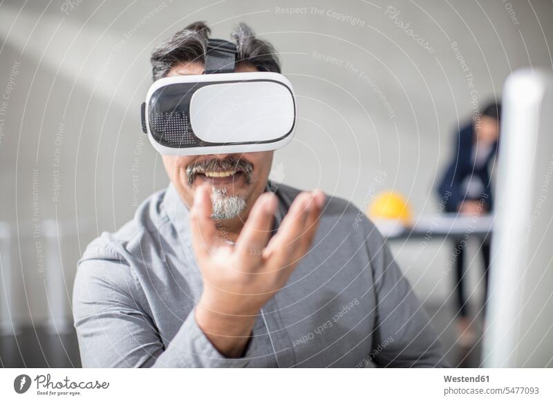 Man wearing VR glasses in office man men males Office Offices specs Eye Glasses spectacles Eyeglasses virtual reality Adults grown-ups grownups adult people