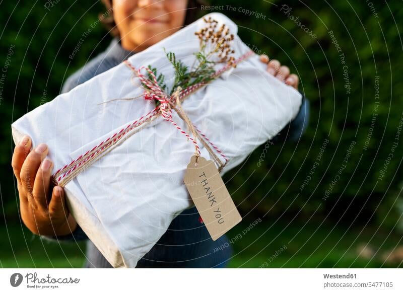 Close-up of boy holding Christmas present in yard color image colour image Spain Christmas presents Christmas Gift gift gifts Surprise surprising X mas X-Mas