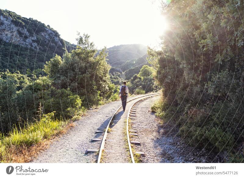 Greece, Pilion, Milies, back view of man walking along rails of Narrow Gauge Railway going men males Adults grown-ups grownups adult people persons human being