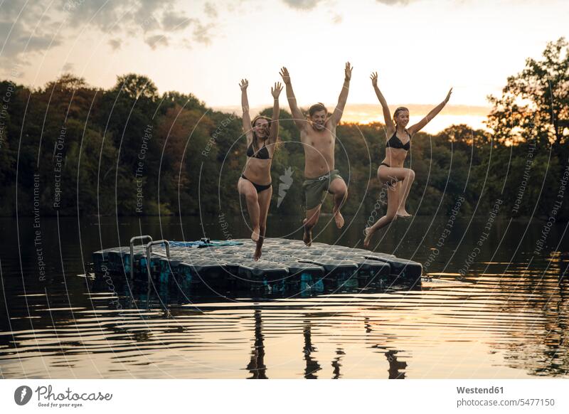 Friends having fun at the lake, jumping from bathing platform human human being human beings humans person persons caucasian appearance caucasian ethnicity