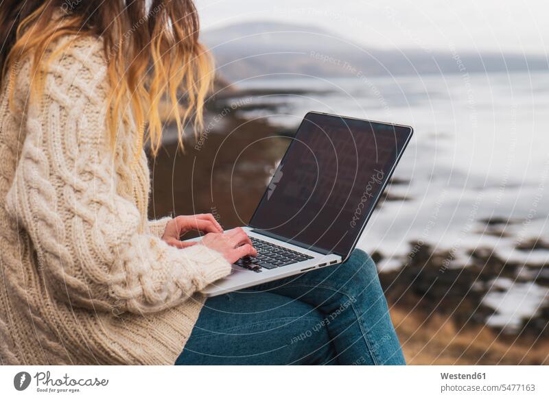Iceland, woman using laptop at the coast females women coastline shoreline Laptop Computers laptops notebook Adults grown-ups grownups adult people persons