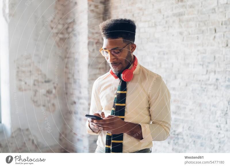 Stylish young man using smartphone in loft human human being human beings humans person persons Mixed Race mixed race ethnicity mixed-race Person 1