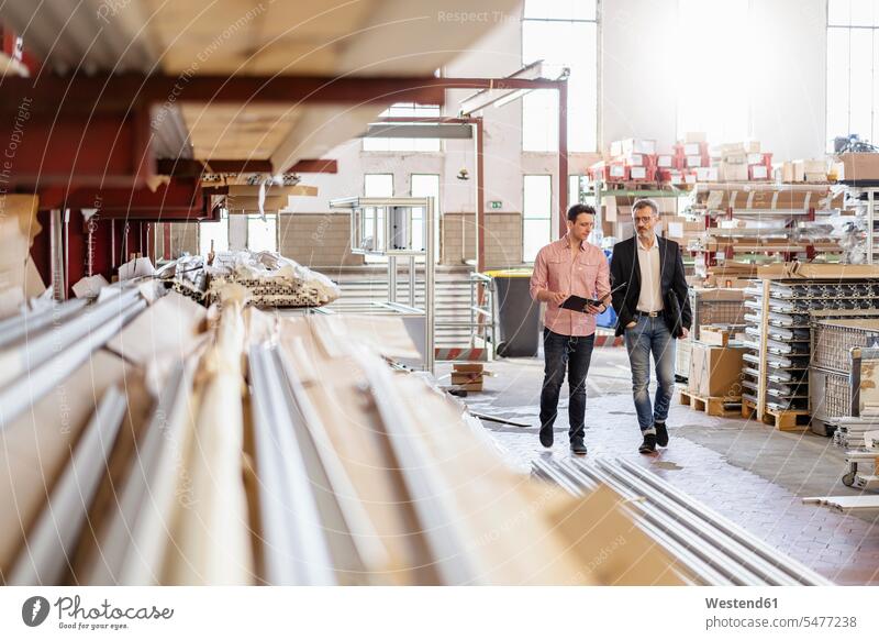 Two men walking in factory warehouse colleagues Businessman Business man Businessmen Business men magazine males going factories business people businesspeople