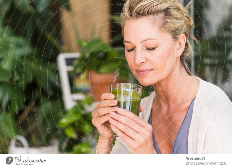 Portrait of mature woman with eyes closed with glass of green smoothie Crockery Tableware Drinking Glass Drinking Glasses relax relaxing enjoy enjoyment