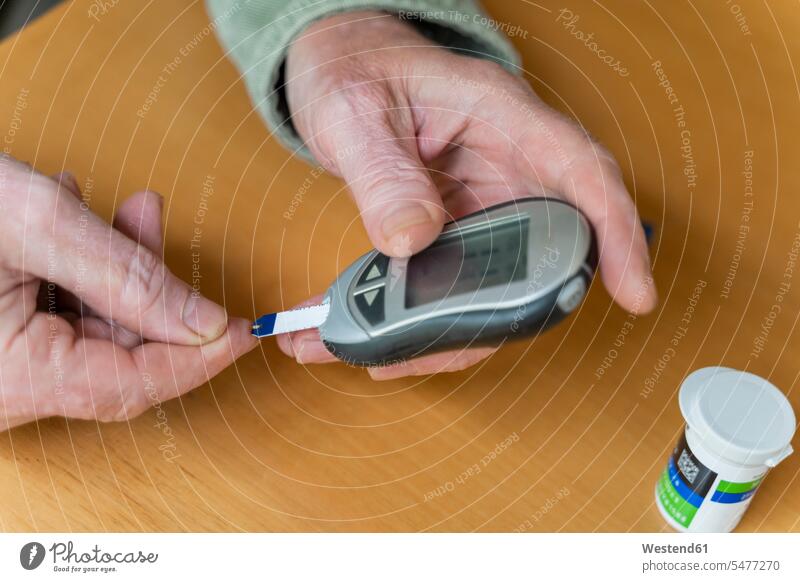 Cropped hands of glaucometer while examining blood sugar test at home color image colour image indoors indoor shot indoor shots interior interior view Interiors