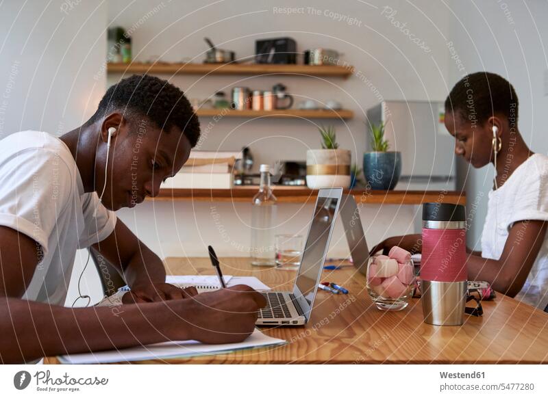 Young couple studying on table at home color image colour image Mozambique Africa Home Interior Home Interiors domestic space domestic life domestic scene