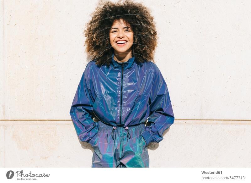 Portrait of happy stylish young woman wearing tracksuit outdoors human human being human beings humans person persons curl curled curls curly hair relax