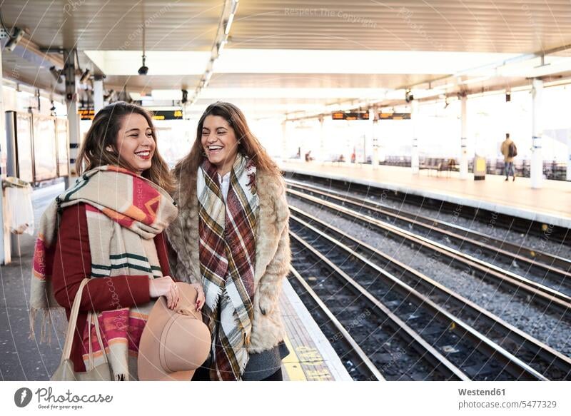 UK, London, two happy women at underground station platform female friends Subway Platform woman females happiness mate friendship underground stations