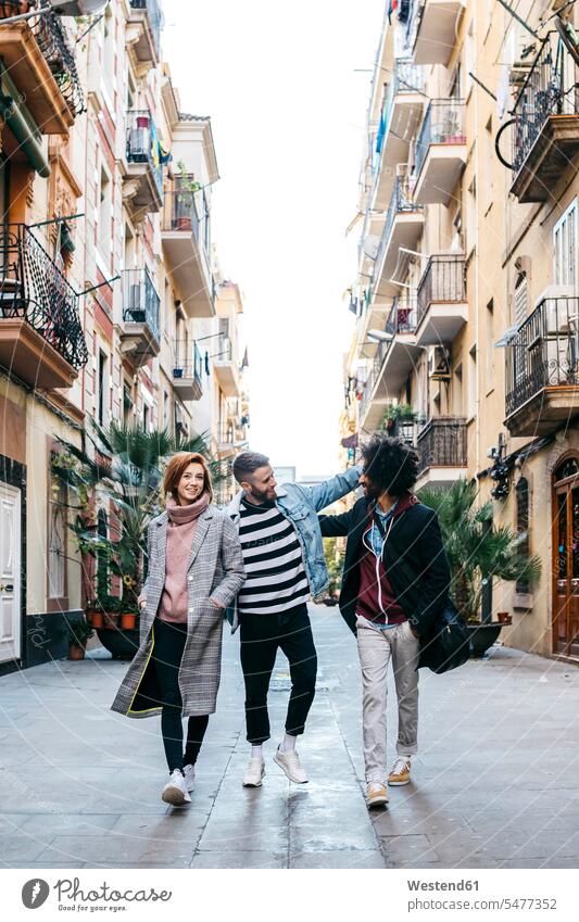 Three happy friends walking in the city town cities towns happiness going friendship outdoors outdoor shots location shot location shots Enjoyment Amusement
