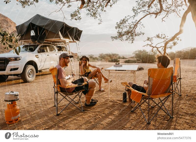 Namibia, friends camping near Spitzkoppe mate mountain mountains sitting Seated friendship landscape landscapes scenery terrain Road Trip roadtrip Road-Trip