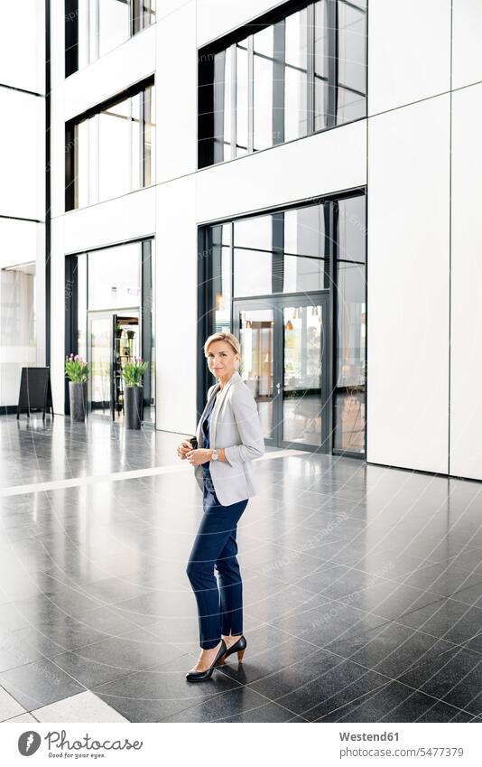 Successful businesswoman standing in entrance hall of office building human human being human beings humans person persons caucasian appearance
