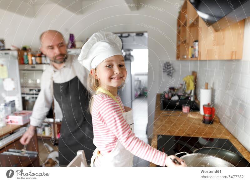 Father and daughter cooking in the kitchen Cookers help learn smile delight enjoyment Pleasant pleasure happy passionate Contented Emotion pleased at home