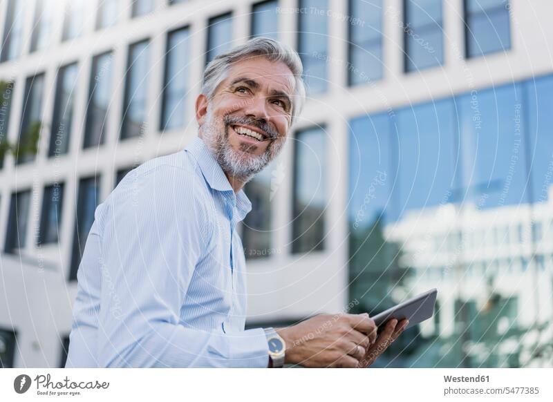 Smiling mature businessman using tablet in the city Occupation Work job jobs profession professional occupation business life business world business person