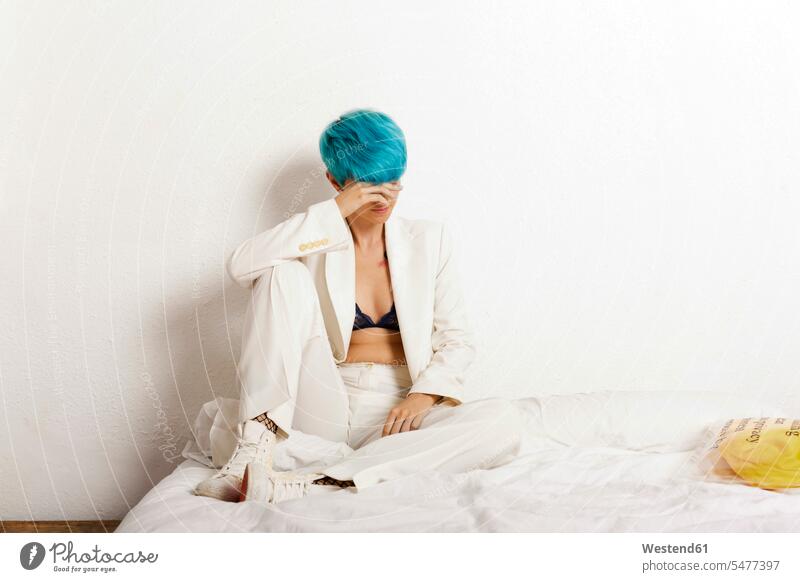 Grunge lesbian woman sitting pensive on bed turquoise Turquoise Color homosexual woman lesbians gay women gay woman homosexual women females Seated thinking